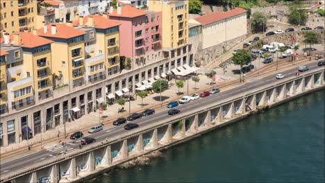 Zeitraffer-Eines-Bürgersteigs-Am-Flussufer-Mit-Vorbeifahrenden-Menschen-Und-Fahrzeugen-In-Porto,-Portugal