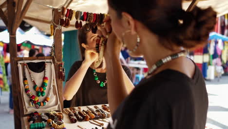 woman trying on handmade jewelry at a local market