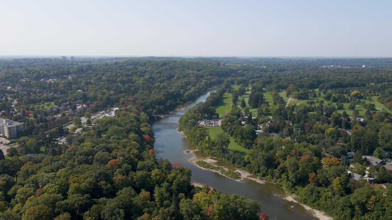 Ripresa aerea di un fiume che attraversa Londra in una giornata estiva velata.