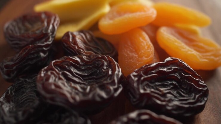 Close-up of Dried Prunes and Apricots on a Wooden Board