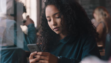 beautiful teenage girl using smartphone drinking coffee in cafe texting sharing messages on social media enjoying mobile technology