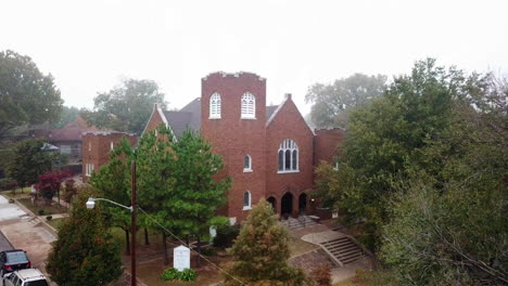 aerial shot of red traditional building surrounded by giant trees