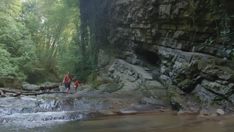 children playing near a waterfall in the forest