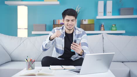 joven ganador mirando el teléfono y regocijándose.