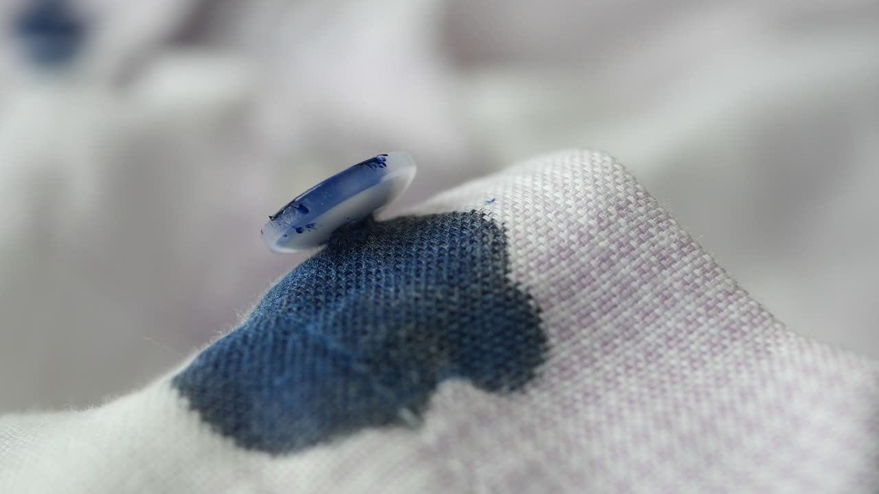 얼룩진 천에 있는 버튼의 클로즈업