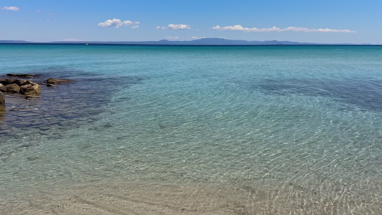 Stunning beach scene in Halkidiki, Greece, with elegant sunbeds facing the crystal-clear turquoise sea. A perfect summer escape in the heart of the Aegean.