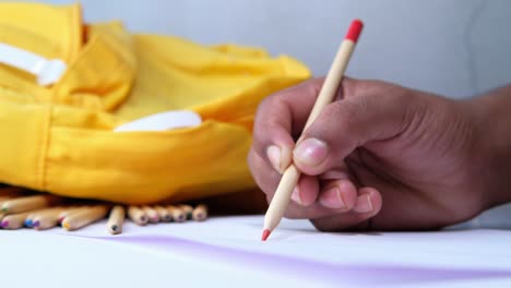 student drawing with backpack and pencils