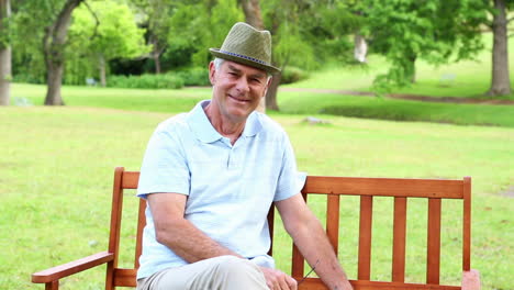 Retired-man-relaxing-with-the-paper-on-a-park-bench