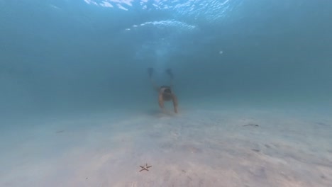 man freediving encounters a starfish