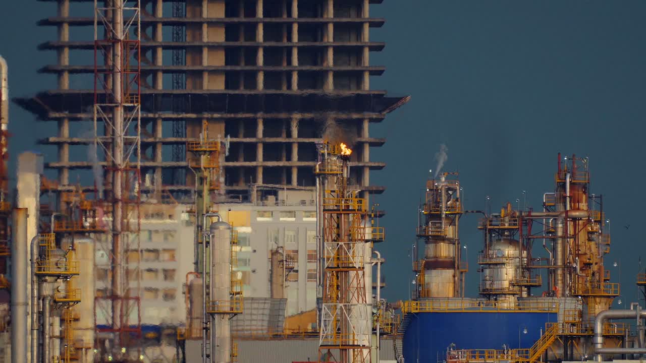 fuego y vapor salen de una refinería de petróleo