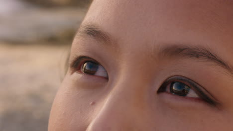 close-up-portrait-of-beautiful-asian-woman-enjoying-seaside-at-sunset-exploring-spirituality-looking-up-praying-contemplating-journey-relaxing-on-beach