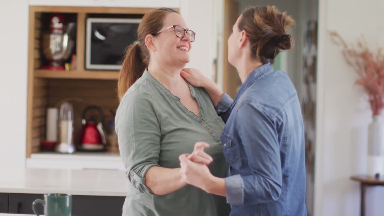 백인 레즈비언 커플이 부 ⁇ 에서 웃고 춤을 추고 있습니다.