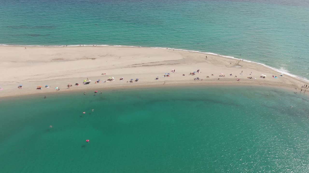그리스 의 포시디 케이프 의 공중 사진 으로, 은 푸른 물 에 둘러싸인 모래 해변 에서 휴식을 취하는 해변객 들 을 보여 준다