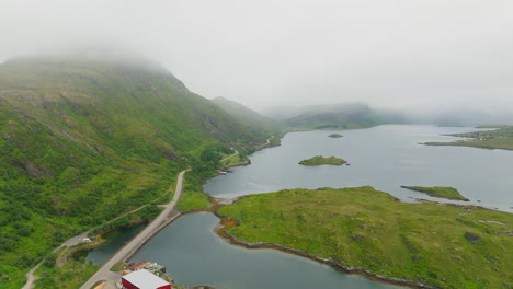 misty green mountains and road near islendingen islet in nordland, lofoten, norway