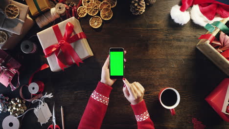 Vista-Superior-De-Manos-De-Mujer-Usando-Tableta-De-Teléfono-Inteligente-Con-Pantalla-Táctil-Regalos-De-Navidad-Mesa-De-Compras-En-Línea-Desde-Arriba---Dragón-épico-Rojo