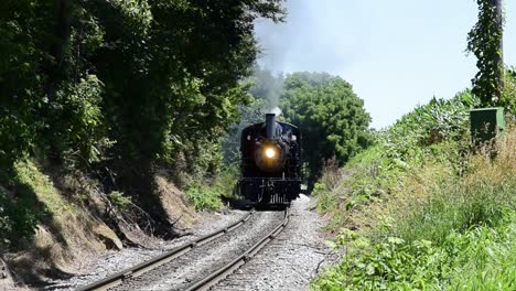 Tren-De-Vapor-Resoplando-A-Lo-Largo-De-Las-Tierras-De-Cultivo-Amish-Visto-Por-Un-Dron