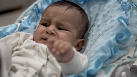 A-six-month-old-infant-attempting-to-touch-and-soothe-an-itch-on-their-head,-exemplifying-the-concept-of-early-sensory-exploration-and-self-comforting-behaviors