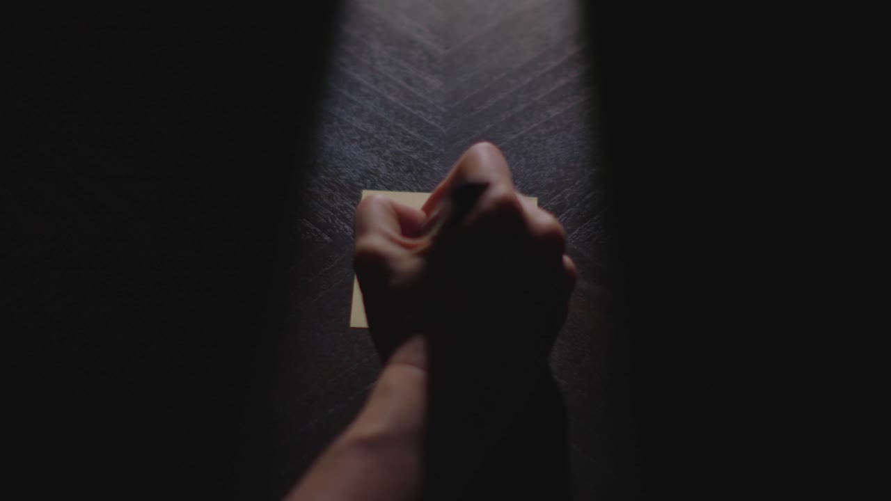 Omicidio? Scritto su un post-it con un pennarello indelebile e posizionato su un tavolo con illuminazione drammatica