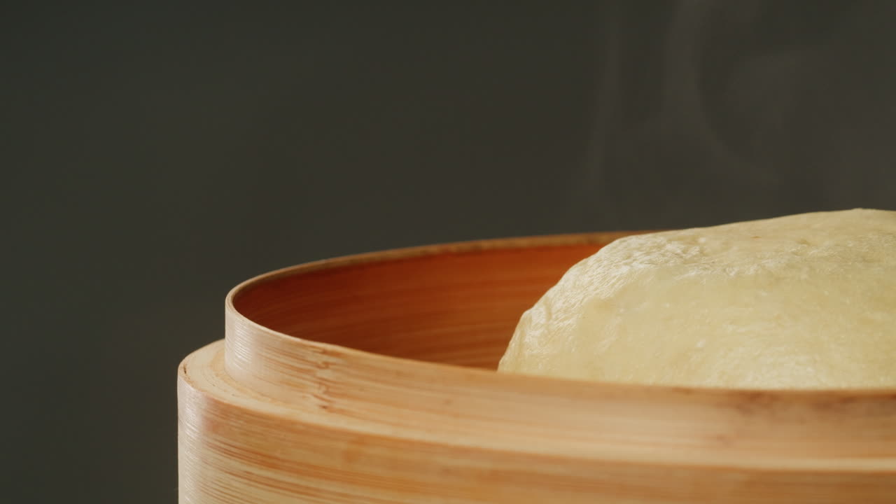 Bakpao kukus panas dalam kukusan bambu dengan uap mengepul