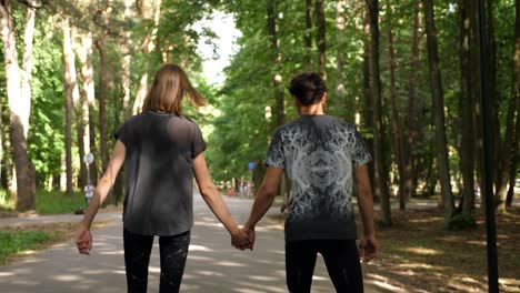 una joven pareja deportiva haciendo ejercicio en el parque, disparada desde la espalda