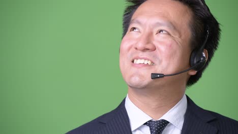 녹색 배경에 성숙한 일본 사업가