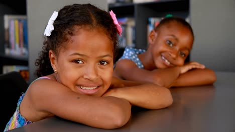 Portrait-of-happy-schoolgirls-leaning-on-table-4k