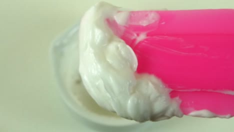 macro shot of a cosmetic laboratory process where gloved hands in blue gloves mix a cream using a porcelain mortar and pestle.