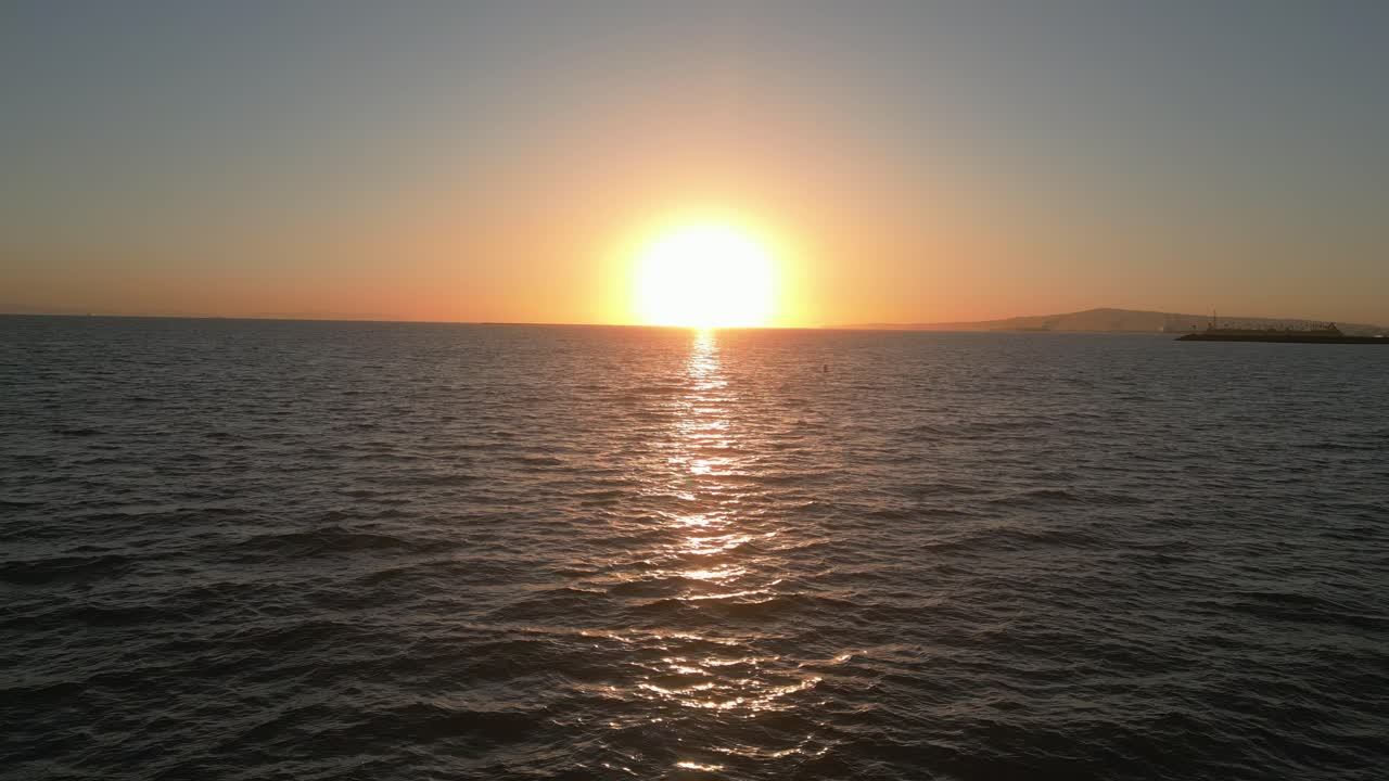 Drone flies forward into peaceful ocean sunset at Seal Beach (60fps)
