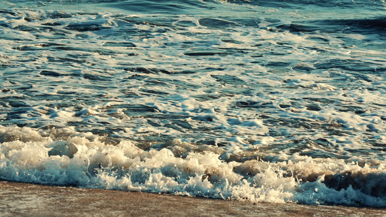 Ondas do oceano quebrando e espumando ao se aproximarem da costa