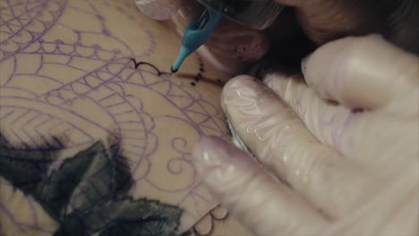 artista del tatuaje en acción en el diseño del mandala
