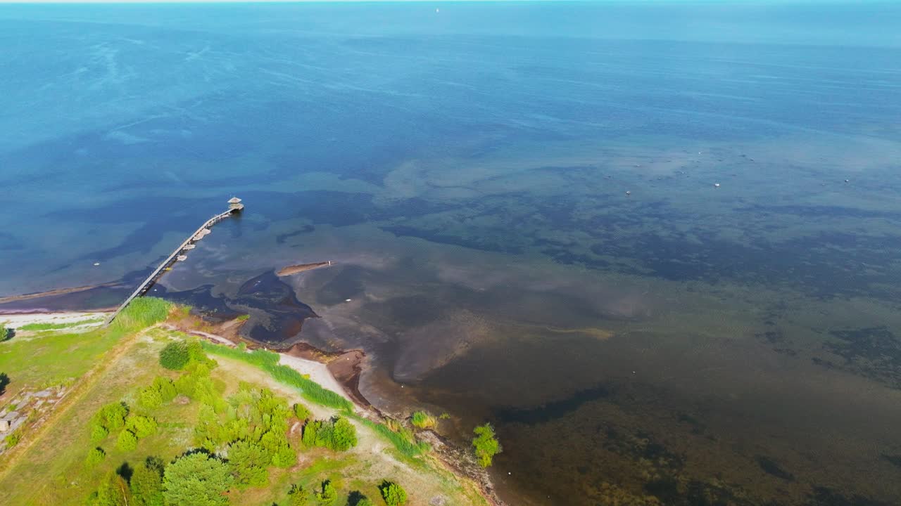 Moving tilt shot of coastline with harbor moving inland, Bl