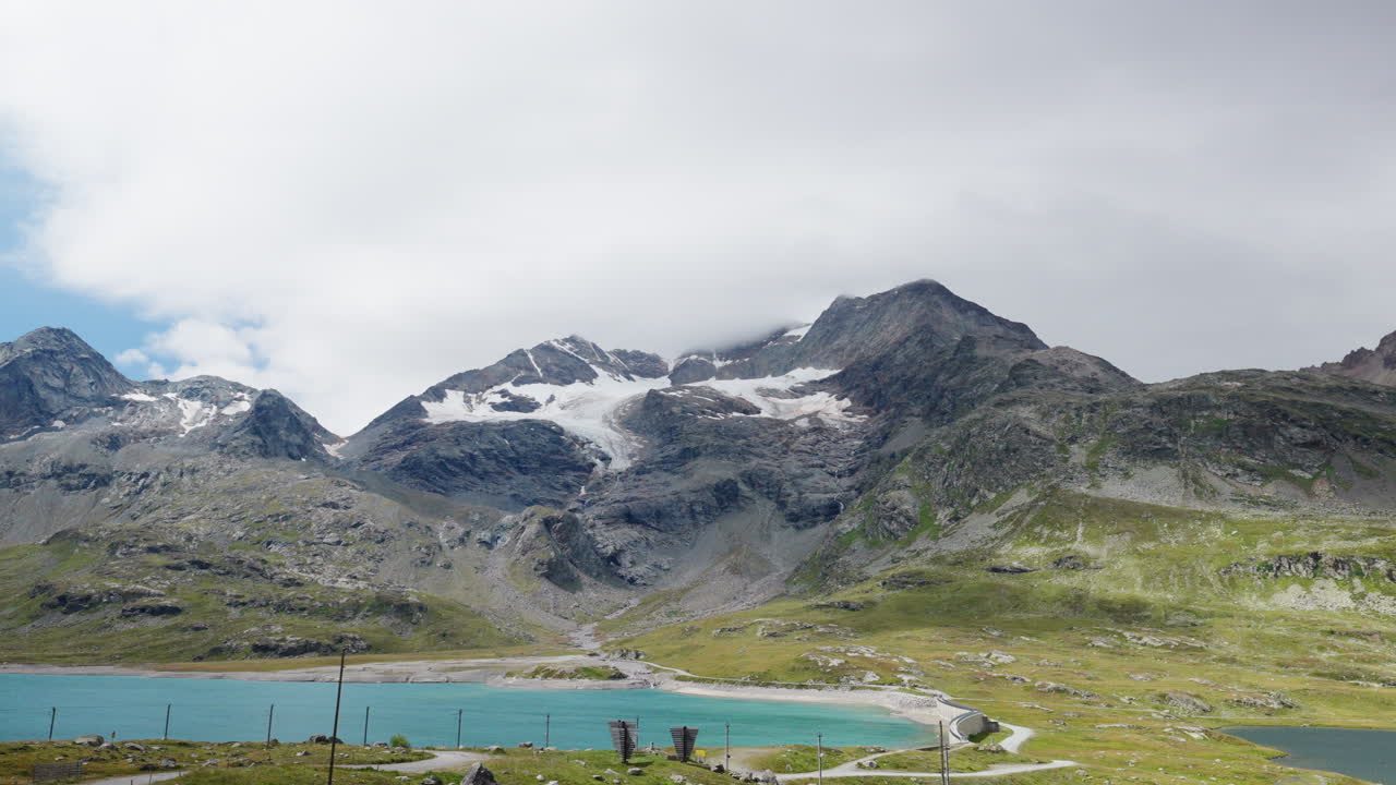 Person in coat admires majestic alpine landscape in Swiss mountains