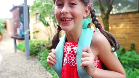 Portrait-of-happy-schoolgirl-standing-in-campus-at-school