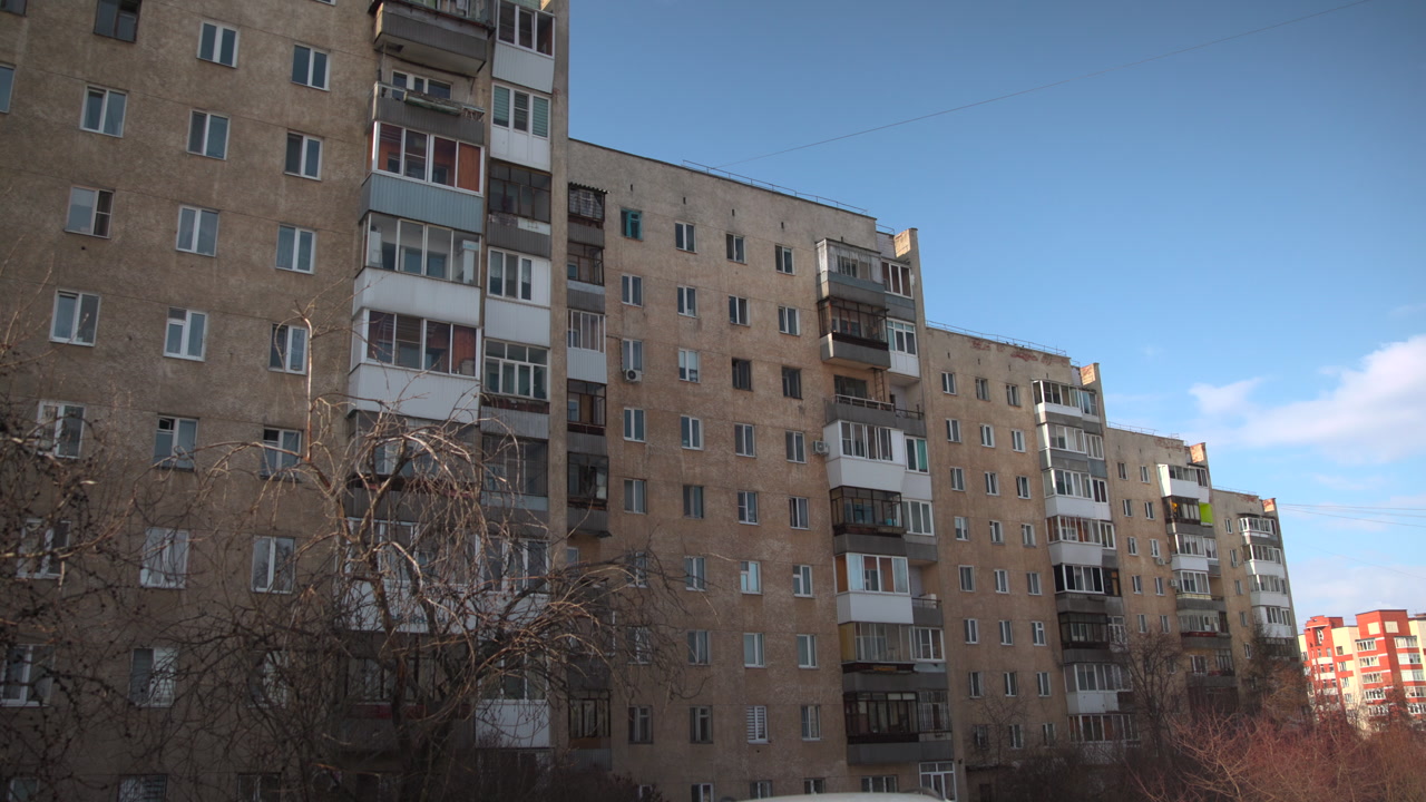 Wide Soviet Apartment Block Bare Trees, Brown Brick Facade With Enclosed Balconies, Lateafternoon Light . Media