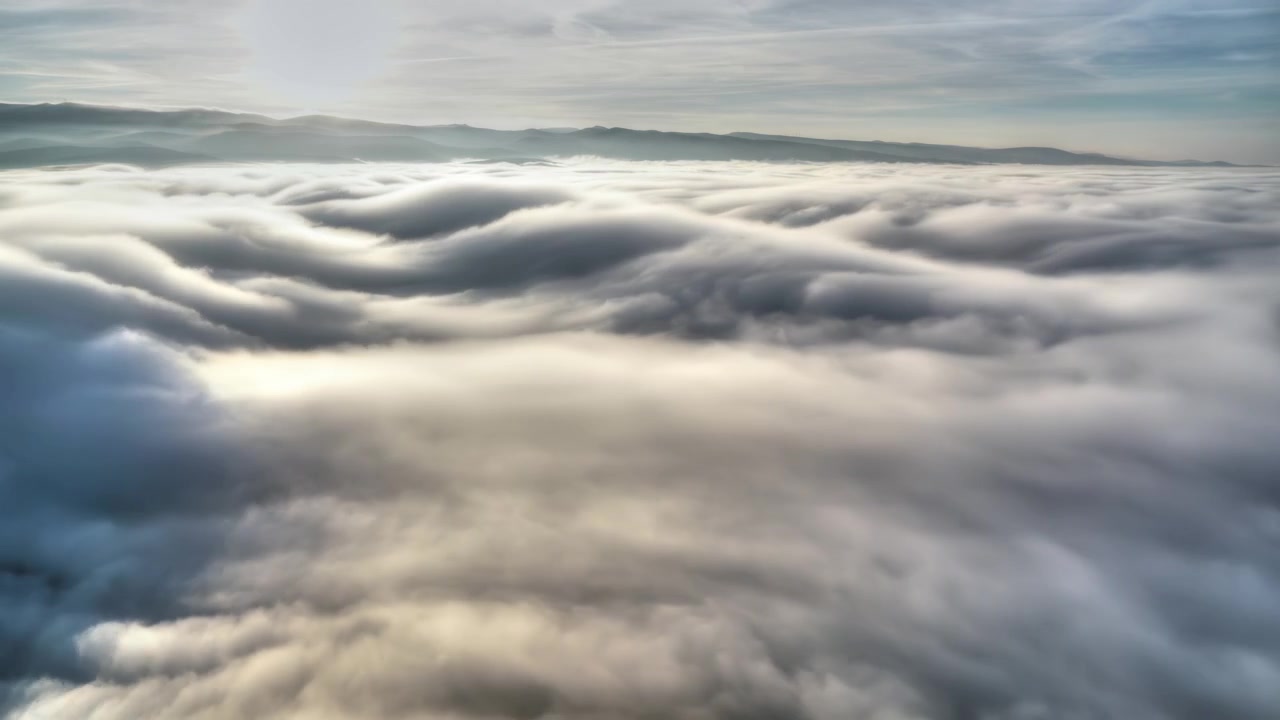 Aerial Time Lapse of Thick Clouds Moving Over Mountain Landscape
