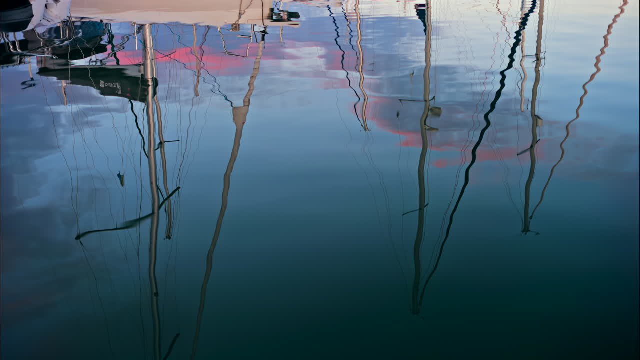 Reflection on the sea of white boats docked in the Port Vauban at sunset in Antibes, France