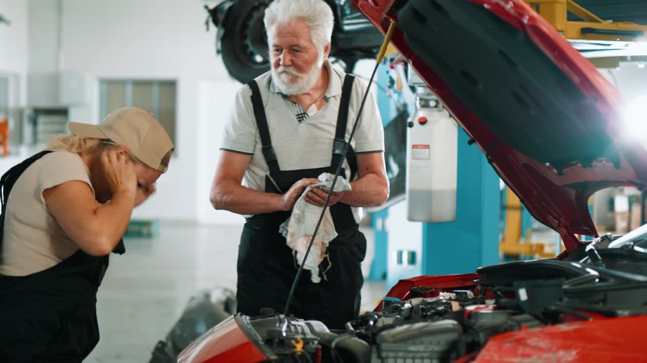 ingeniero mecánico profesional de automóviles y trabajadora femenina de pie en el capó abierto del automóvil y estimando el daño. reparando el automóvil dañado