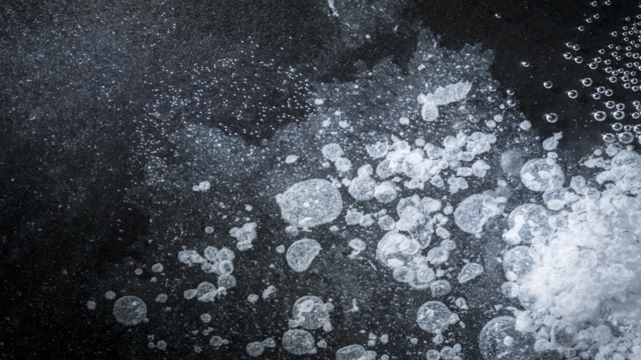 Bubbles and particles mixing together in a dynamic macro shot, abstract textures