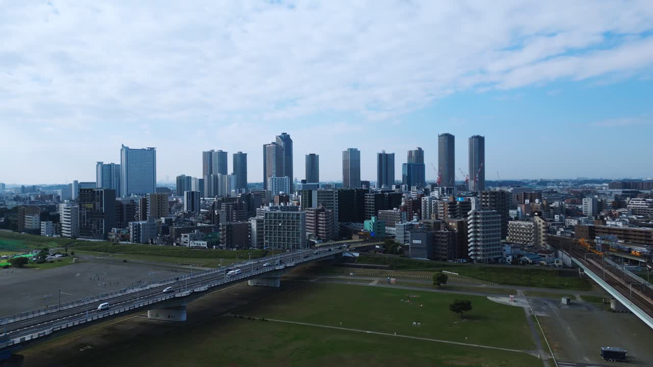Smooth forward drone flight over Musashi Kosugi skyline under blue sky