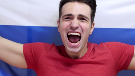 russian young man celebrates holding the flag of russia in slow motion