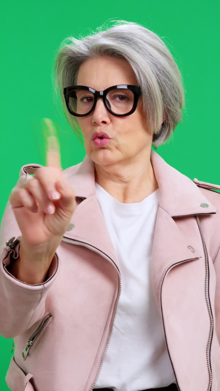 Donna matura che scuote la testa e agita il dito con disapprovazione.