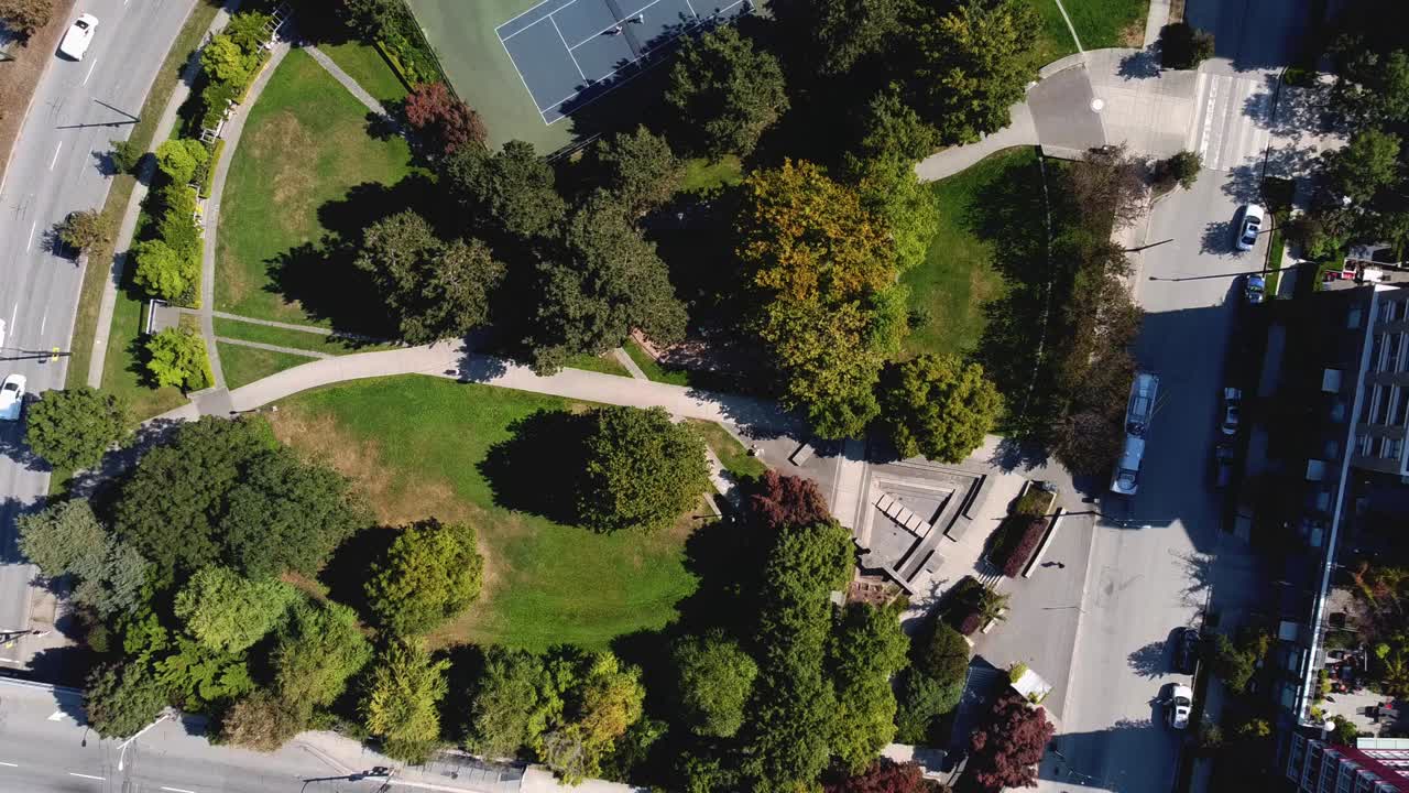 elevación aérea sobre un exuberante parque circular urbano moderno dentro de una comunidad residencial de lujo en el centro junto a un servicio de autobús de transporte público ecológico conectado a líneas de tranvía eléctrico por el puente 1-3