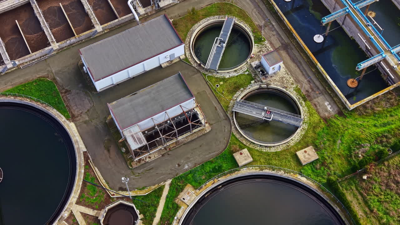 Water treatment facility reveals intricate patterns and structures in the circular tanks during a bright afternoon