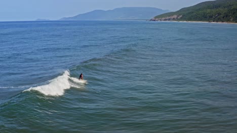 Erstaunlicher-Surfer,-Der-Wellenbrecher-Reitet-Und-In-Tropisches-Wasser-Stürzt,-Luftdrohne-Folgt
