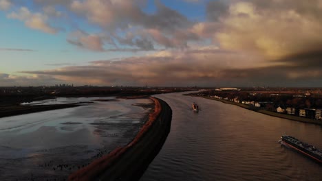 Buque-De-Carga-Industrial-Cruza-El-Río-Noord-Con-Cielo-Nublado-Al-Atardecer-En-Países-Bajos