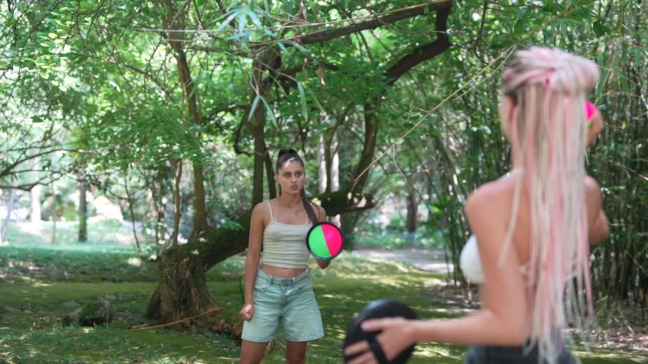 Two women playing paddleball in the park