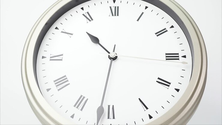 Time lapse silver wall clock tells the time 11 o'clock.