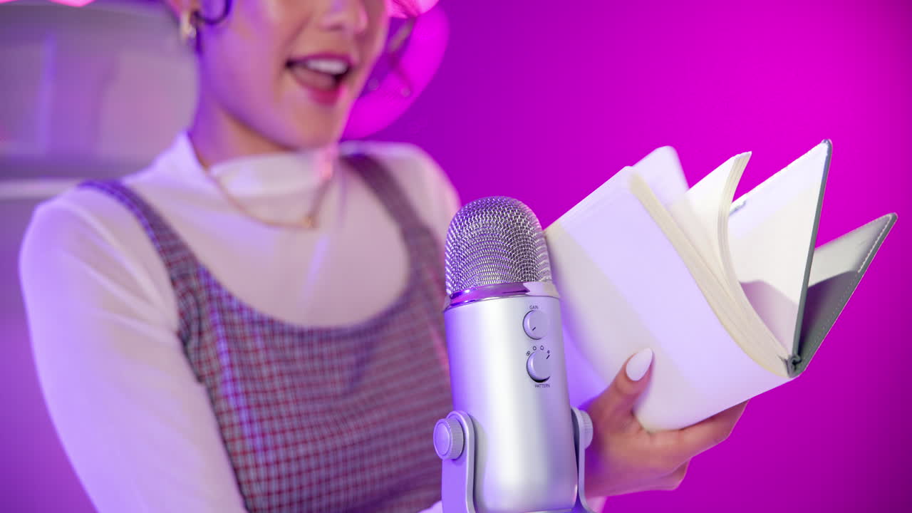 Woman recording podcast with microphone and book
