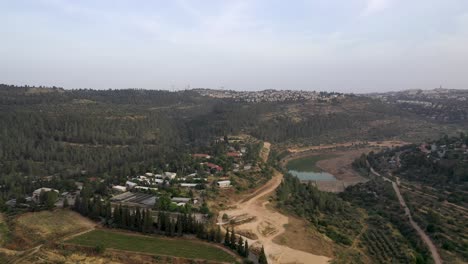 Toma-Aérea-Sobre-Un-Pequeño-Asentamiento-Dentro-De-Un-área-Boscosa-En-Las-Montañas-De-Jerusalén,-Toma-De-Drones