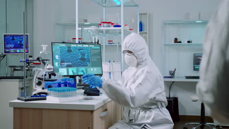 médico con traje de protección trabajando con muestras de sangre